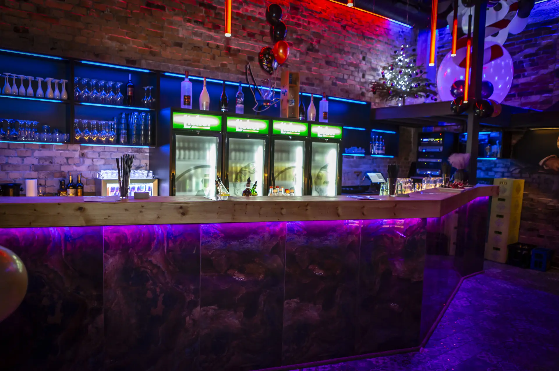Die lange Bar im Liebig mit Kühlschränken und violettem Licht